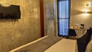 1 dormitorio con 1 cama y TV de pantalla plana en Hotel Casa Panama, en Panamá