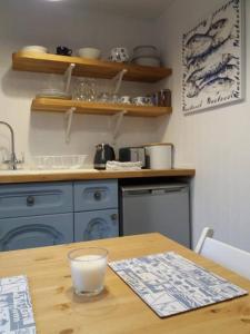 cocina con armarios azules y mesa de madera en The Bake House (Berryl Farm Cottages), en Whitwell
