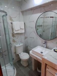 W łazience znajduje się toaleta, umywalka i lustro. w obiekcie Kallikratia Suites w miejscowości Nea Kallikratia
