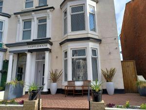 una casa con dos sillas y una mesa frente a ella en The Copplehouse, en Southport