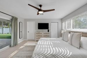 1 dormitorio blanco con 1 cama y ventilador de techo en Kasa Palm Grove Fort Lauderdale, en Fort Lauderdale