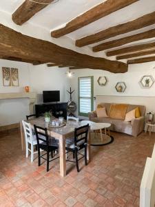 a living room with a table and chairs and a couch at Maisons de campagne. Gîte vert. in Brigné