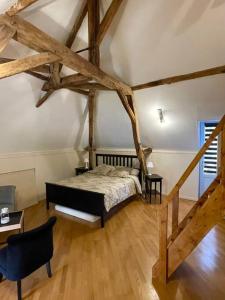 a bedroom with a bed in a room with wooden floors at Maisons de campagne. Gîte vert. in Brigné