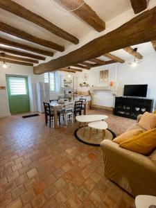 a living room with a couch and a table at Maisons de campagne. Gîte vert. in Brigné