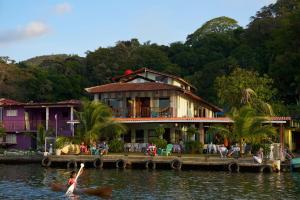 a woman in a kayak on the water in front of a house at Casa Congo - Rayo Verde - Restaurante in Portobelo