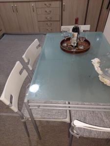 - une table bleue avec 2 chaises et une bouteille de vin dans l'établissement Υπεροχο διαμέρισμα ηλιουπολης, à Athènes