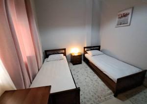 - 2 lits dans une petite chambre avec une lampe dans l'établissement Υπεροχο διαμέρισμα ηλιουπολης, à Athènes