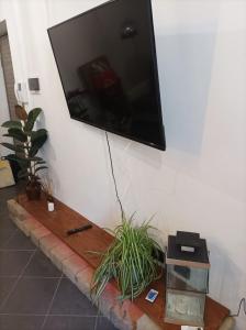 a flat screen tv hanging on a wall with a fish tank at glamhouse in Nizza Monferrato