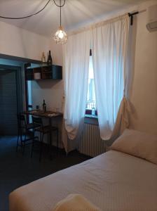 a bedroom with a bed and a table and a window at glamhouse in Nizza Monferrato