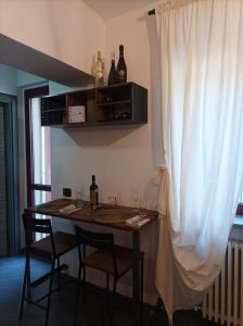 a dining room table with two chairs and wine bottles at glamhouse in Nizza Monferrato