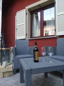 a bottle of wine sitting on a table with two glasses at glamhouse in Nizza Monferrato