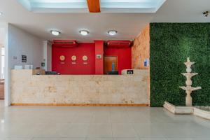 a lobby with red walls and a green wall at Hotel Maya Yucatan in Mérida