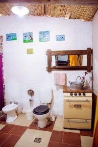 a bathroom with a toilet and a sink and a stove at Apapacho Hostel in Tilcara