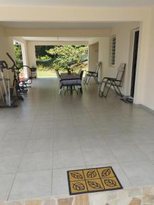 a patio with chairs and a rug on a tile floor at Charmant logement situé à la campagne avec spa in Le Robert