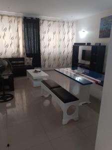 Habitación con escritorio, mesa y banco. en Bellamy en Porto Novo