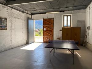 una mesa de ping pong en una habitación con ventana en El Molí, en Ulldemolins