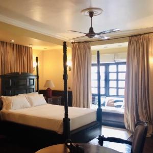 a bedroom with a bed and a ceiling fan at Courtyard Pujan Hotel in Kathmandu
