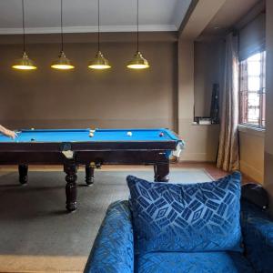 a living room with a pool table and a couch at Courtyard Pujan Hotel in Kathmandu