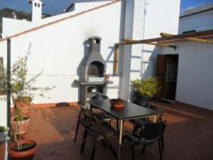 eine Terrasse mit einem Tisch und einem Backofen im Freien in der Unterkunft Casa Las Lomas in Prado del Rey