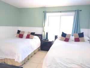 two beds in a room with a window at TWO Bedroom TWO Bath Family Condo - Sleeps Four - Unit B - Private Beach in St Petersburg +71 photos