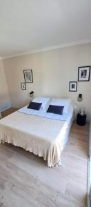 a bedroom with a large white bed with black pillows at Villa Junna in Fréjus
