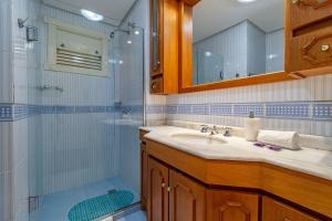 een badkamer met wastafel en douche bij Rosa Edifício English Place in Gramado +17 foto's