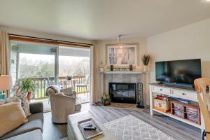 a living room with a television and a fireplace at Ocean Shores Condo with Balcony Less Than 1 Mi to Beach! in Ocean Shores