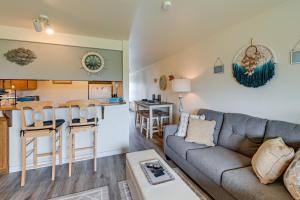 sala de estar con sofá y cocina en Ocean Shores Condo with Balcony Less Than 1 Mi to Beach!, en Ocean Shores