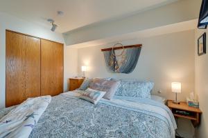 a bedroom with a bed with a blue and white comforter at Ocean Shores Condo with Balcony Less Than 1 Mi to Beach! in Ocean Shores