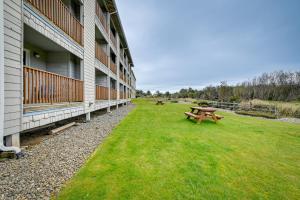 a building with a picnic table in the grass next to it at Ocean Shores Condo with Balcony Less Than 1 Mi to Beach! in Ocean Shores