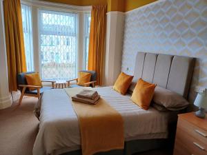 1 dormitorio con 1 cama grande con almohadas de color naranja en The Copplehouse, en Southport