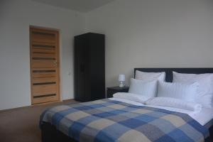 sypialnia z łóżkiem z niebiesko-białym kocem w obiekcie Salvia apartment w Kownie