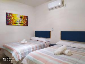 una camera con due letti e un dipinto sul muro di Condominio Casas Mandala a Costa Esmeralda