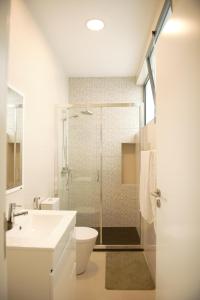 a bathroom with a shower and a toilet and a sink at Duarte Apartments - Morabeza in Mindelo