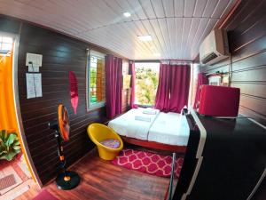 een kleine kamer met een bed en een gele stoel bij Wow Farm House & Resort near Pondicherry in Auroville