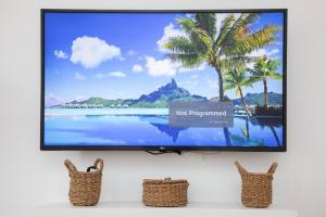 a flat screen tv hanging on a wall with two wicker chairs at BRAND NEW City Center Apartment Nostalgija in Split