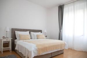 a white bedroom with a large bed and a window at BRAND NEW City Center Apartment Nostalgija in Split