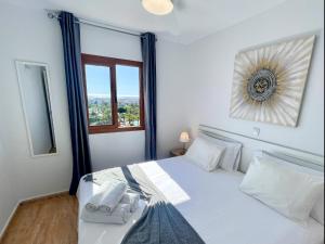une chambre avec un lit blanc avec une fenêtre dans l'établissement Blue Ocean Holiday Home, à Playa del Ingles 31 autres photos