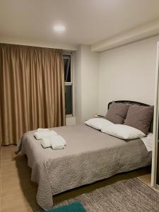 een slaapkamer met een bed met twee handdoeken erop bij My home in Amaliás