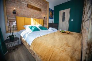 a bedroom with a large bed with a brick wall at Czocha Studio Apartment in Leśna