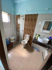 a bathroom with a toilet and a sink at 2BHK Luxurious Villa with Pool in Shenwa