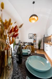 a table with two plates and a bottle of wine at Hlavna Apartment Kosice in Košice