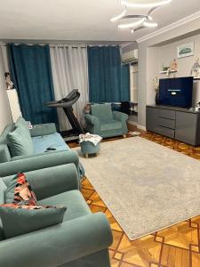 a living room with two blue couches and a television at 2-х комнатная квартира in Pizunda