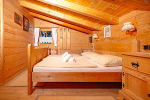 um quarto com uma cama num chalé de madeira em Magdalena Hütte em Hippach