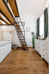 a bedroom with a wooden staircase in a loft at Hlavna Apartment Kosice in Košice