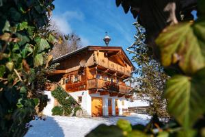uma grande casa de madeira na neve em Magdalena Hütte em Hippach