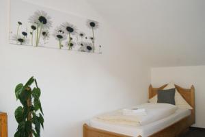 a bedroom with a bed with flowers on the wall at Gasthof zum Hirsch 