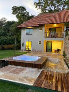 een achtertuin met een zwembad en een huis bij Chalé Novo - 4 quartos - 12 camas - Hidromassagem e Ar condicionado nos quartos - Cond Montserrat in Guaramiranga
