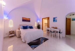 卡普里Suite Posterus 5的一间带床和桌子的白色卧室
