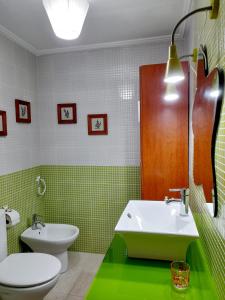 a green bathroom with a sink and a toilet at Mi rincón de Rota in Rota